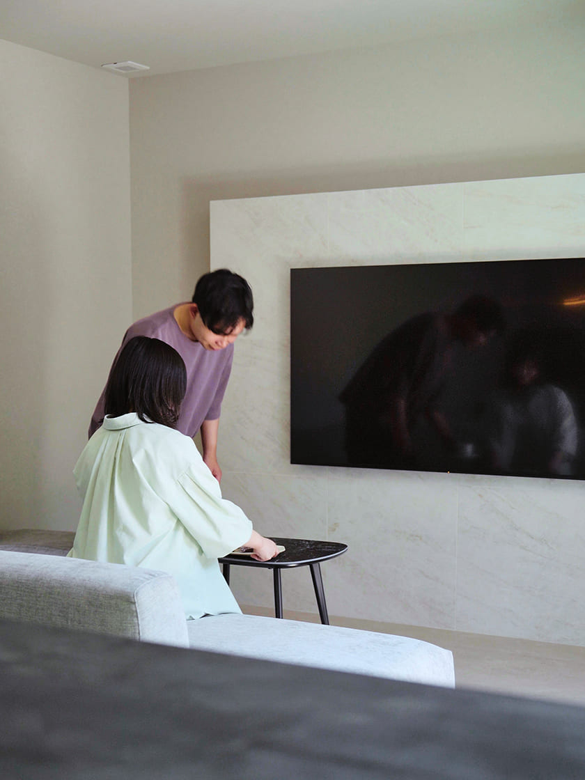 壁掛けテレビの前でくつろぐふたり