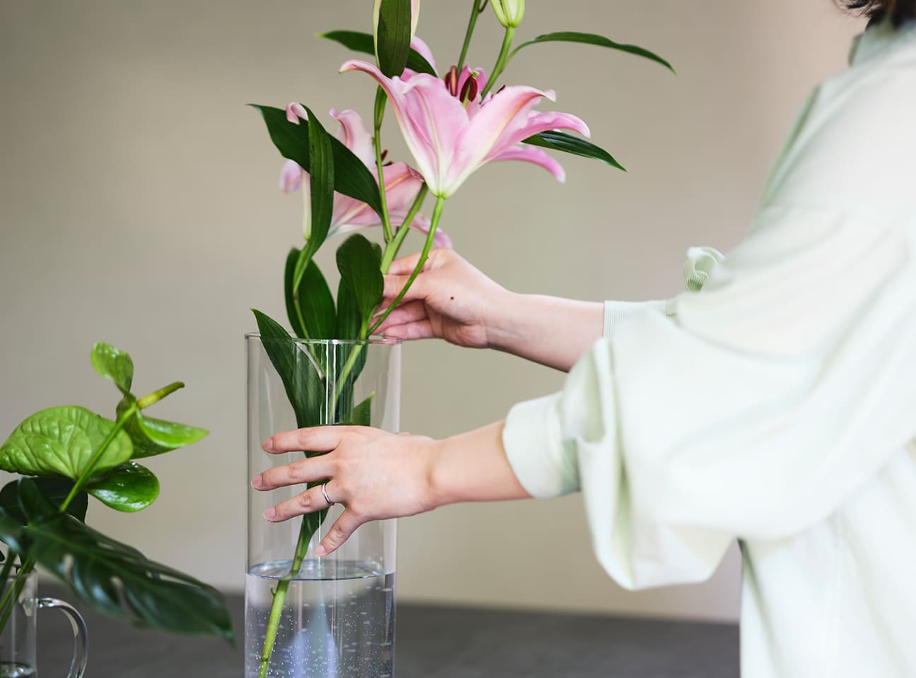 ピンクのユリを花瓶に生ける手元