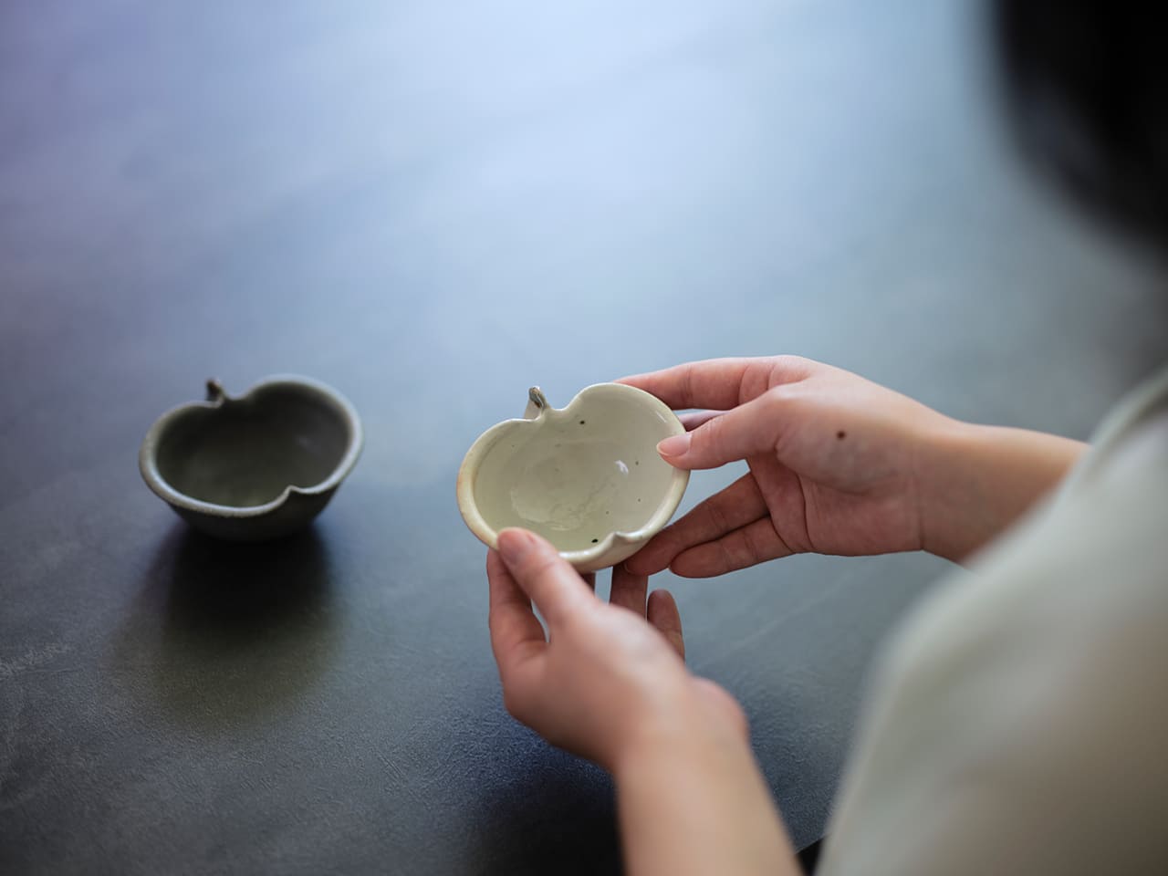 りんごの形をした器を手に取るみなみさん